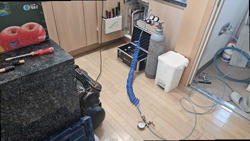 아산시 누수탐지 싱크대 하부장과 젖은 벽지 주변을 점검하는 모습