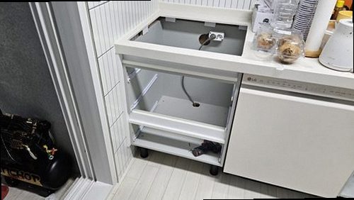 양천구 누수탐지 싱크대 하부장과 벽면의 누수 흔적을 확인하는 모습